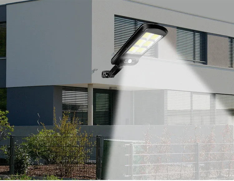 Black outdoor solar-powered motion sensor security light with solar panel on top.