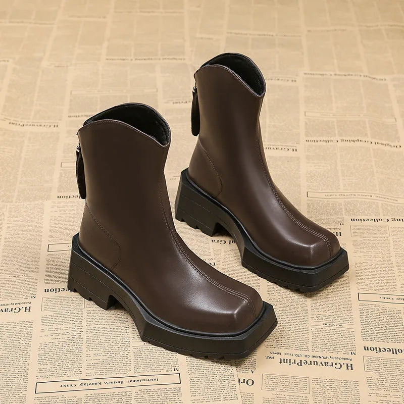 Women's black platform Martin ankle boots with square toe, chunky heel, and back zipper on a plain background.