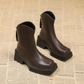 Women's black platform Martin ankle boots with square toe, chunky heel, and back zipper on a plain background.