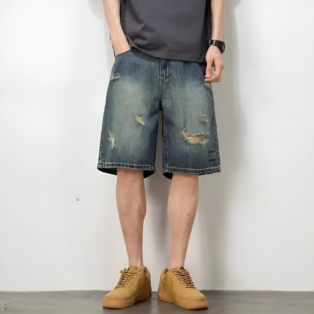Man wearing blue retro-style loose denim shorts with a straight leg cut.