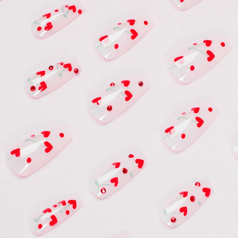 Set of 24 cherry blossom French manicure press-on nails with red diamond accents and glue tube