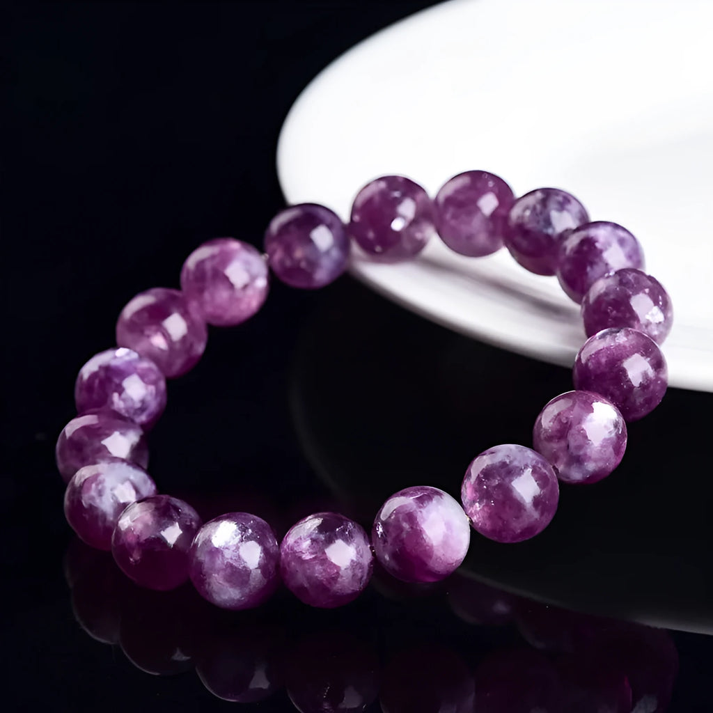 Grandmother Crystal Bracelet with polished purple beads in geometric shapes on a wrist.