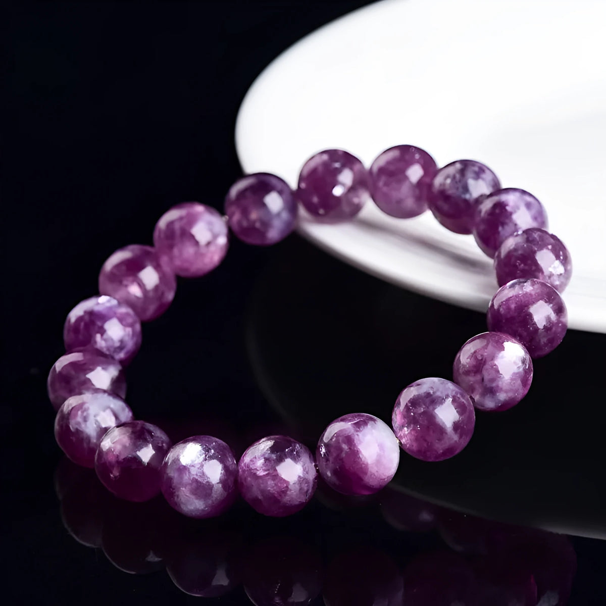 Grandmother Crystal Bracelet with polished purple beads in geometric shapes on a wrist.