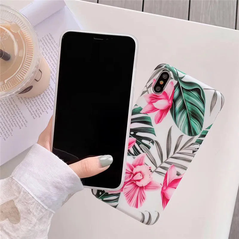 Pink floral pattern TPU back cover case for iPhone on a wooden table.