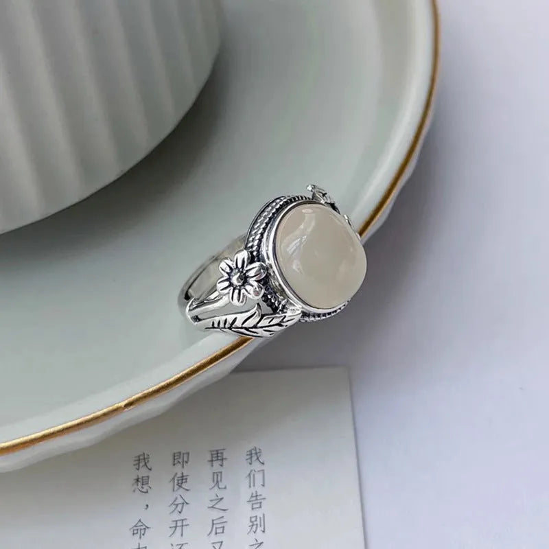 Adjustable vintage copper ring with a white imitation chalcedony stone on a U-shaped band.