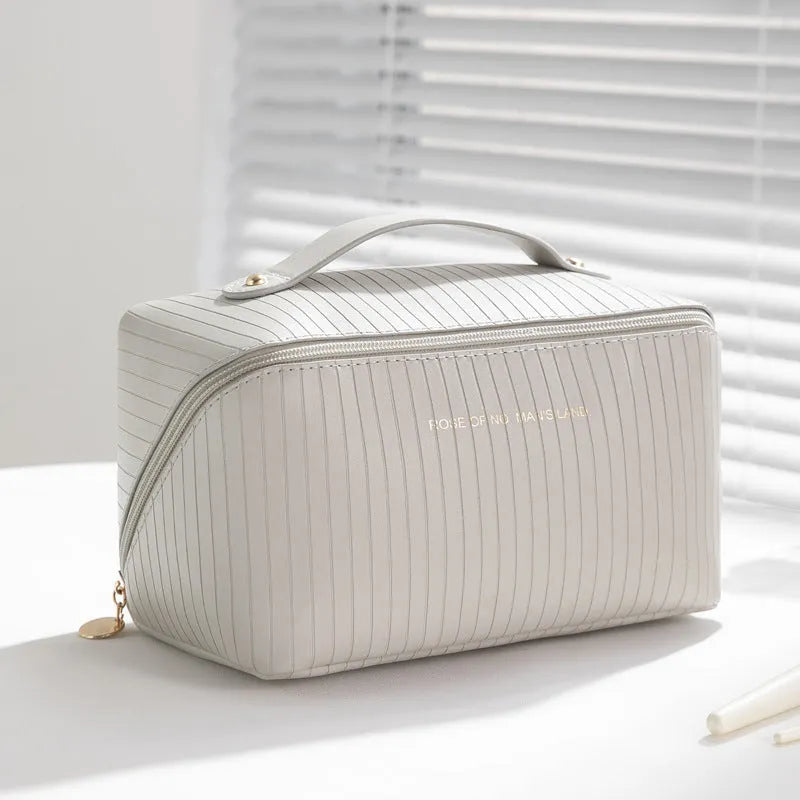 Vertical striped cubic makeup bag in beige with 22.5cm dimensions showing open interior