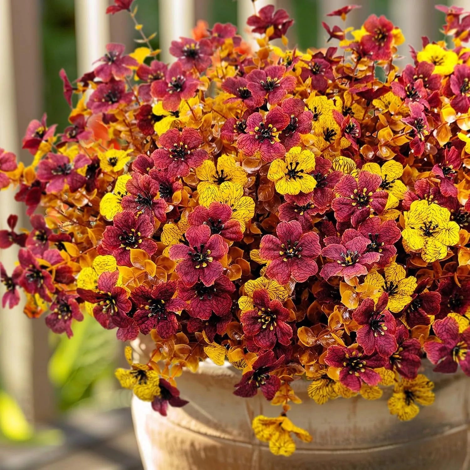 Artificial flower bouquet in autumn colours of red, yellow, orange, and orange yellow for home decoration