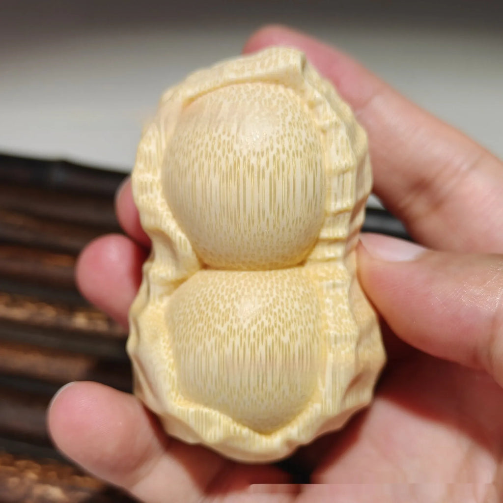 Solid bamboo peanut ornament carving on a plain background