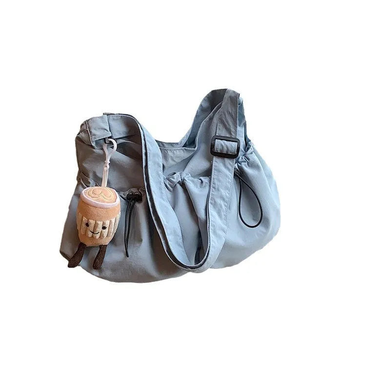 Soft green pleated polyester crossbody bag with a split pocket, shown folded and open with phone pocket visible.