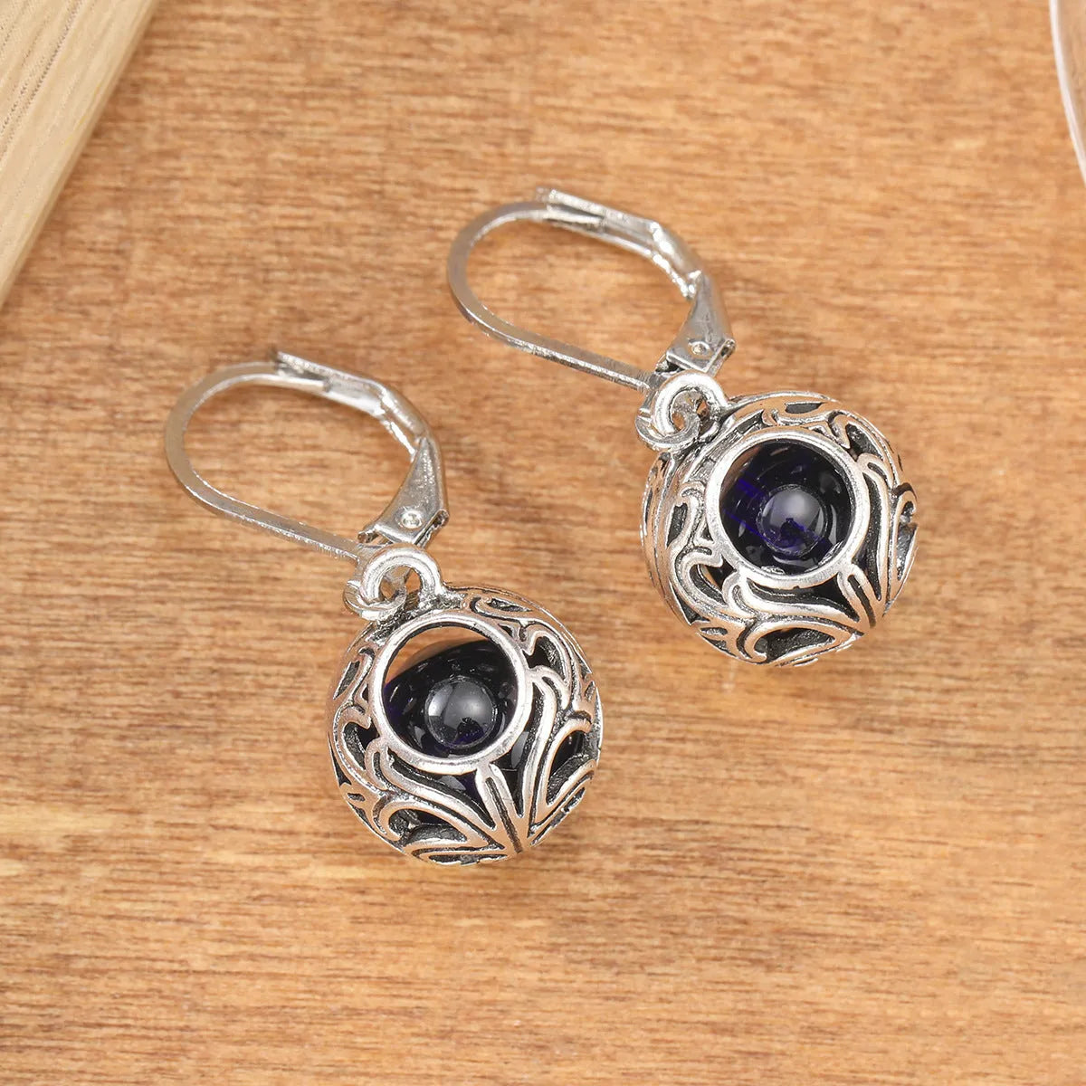 Silver geometric pendant earrings with vintage engraving and blue gemstone, shown from front view