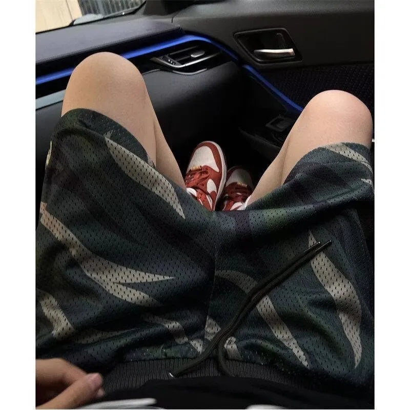 Men's straight-leg camouflage shorts in a cotton blend fabric, shown in a casual setting.
