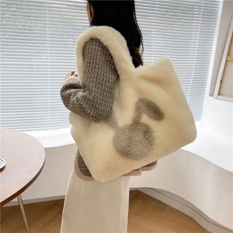 Soft plush tote bag with cartoon rabbit ears on the front in a solid colour.
