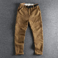 Men's khaki cotton work trousers with a flat buckle belt and zip fly, showcasing three-dimensional leg cutting.