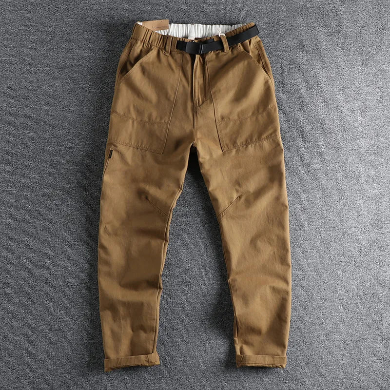 Men's khaki cotton work trousers with a flat buckle belt and zip fly, showcasing three-dimensional leg cutting.