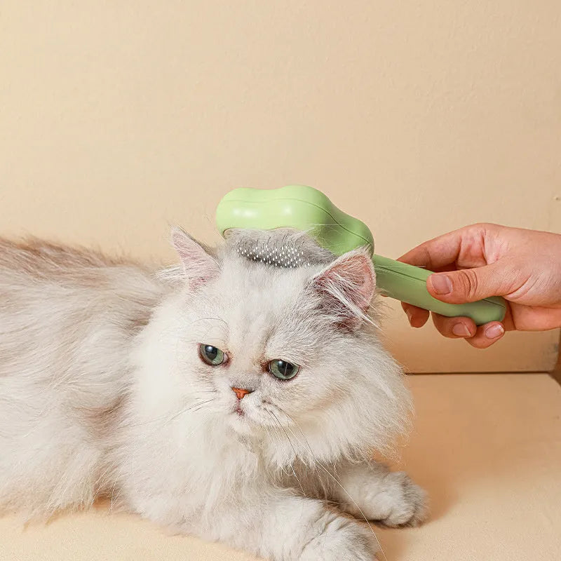 Green self-cleaning magic wand cat comb with stainless steel needle teeth on a white background.