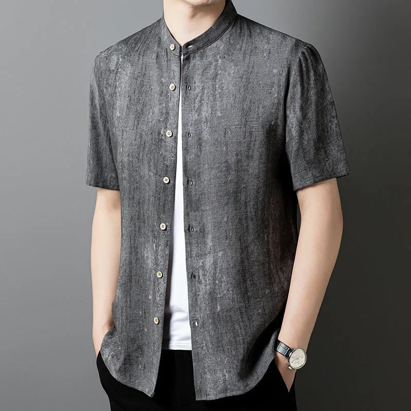 Man wearing a loose-fit black grey linen cardigan-style shirt with a stand collar and short sleeves.