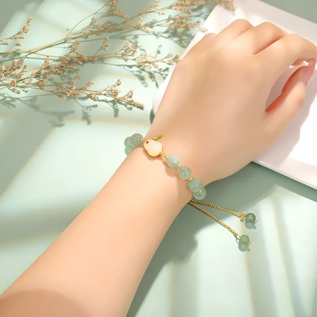 Women's rabbit charm bracelet with green aventurine or strawberry quartz beads, copper and gold accents.