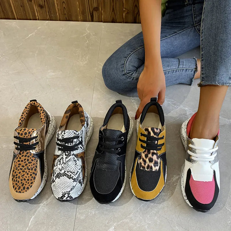 Women's black casual sneakers with a suede upper and a low wedge heel on a plastic sole.