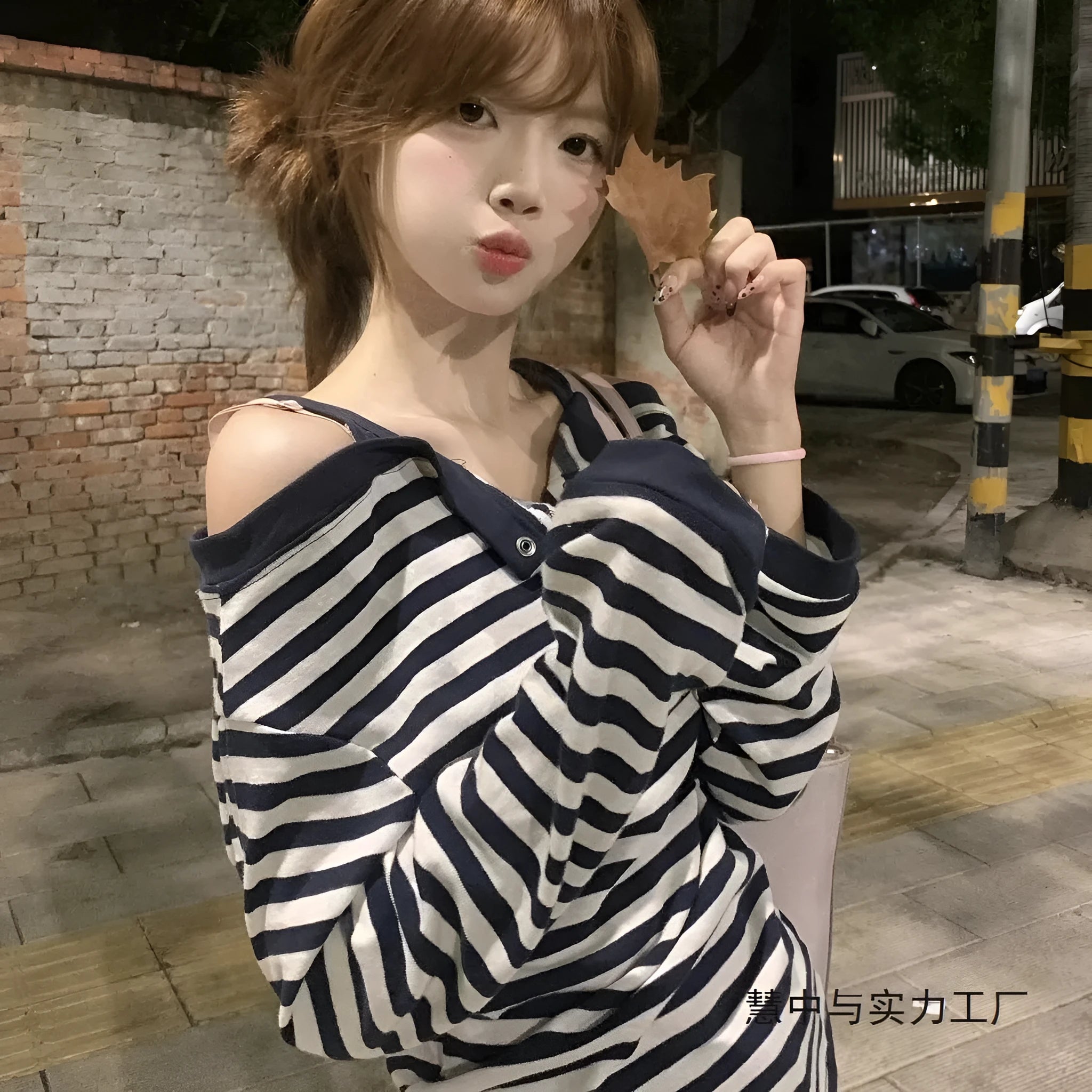 Dark blue women's long-sleeved oversized T-shirt with embroidery and striped detail on a hanger.