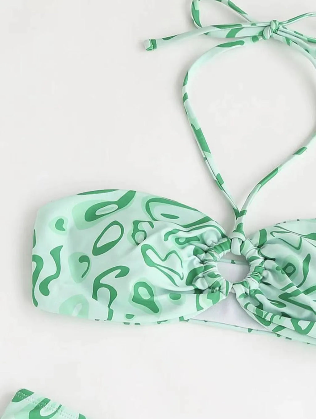 Green floral bandeau bikini swimsuit with split style bottom and backless design on mannequin