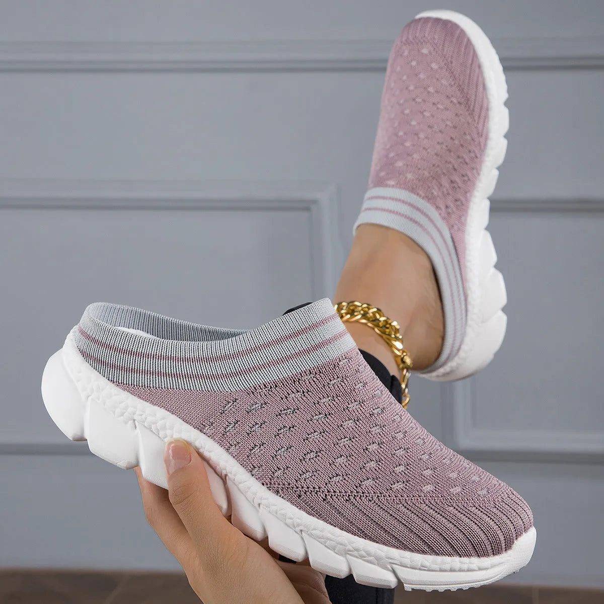 Women's black Flyknit slipper sock with striped pattern and hollowed-out design on a solid background.