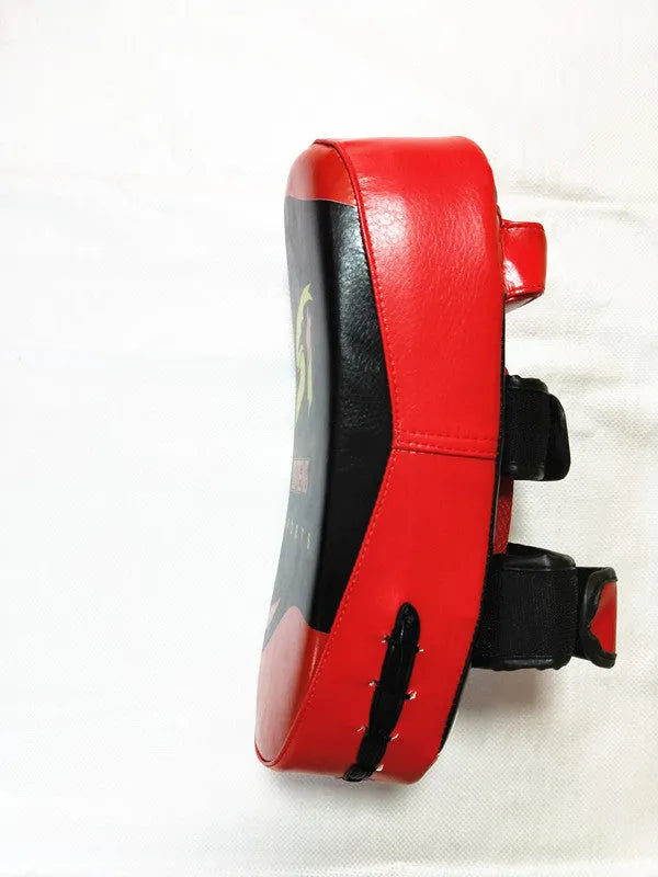 Red and black square hand-held martial arts training pad for kicks and punches.