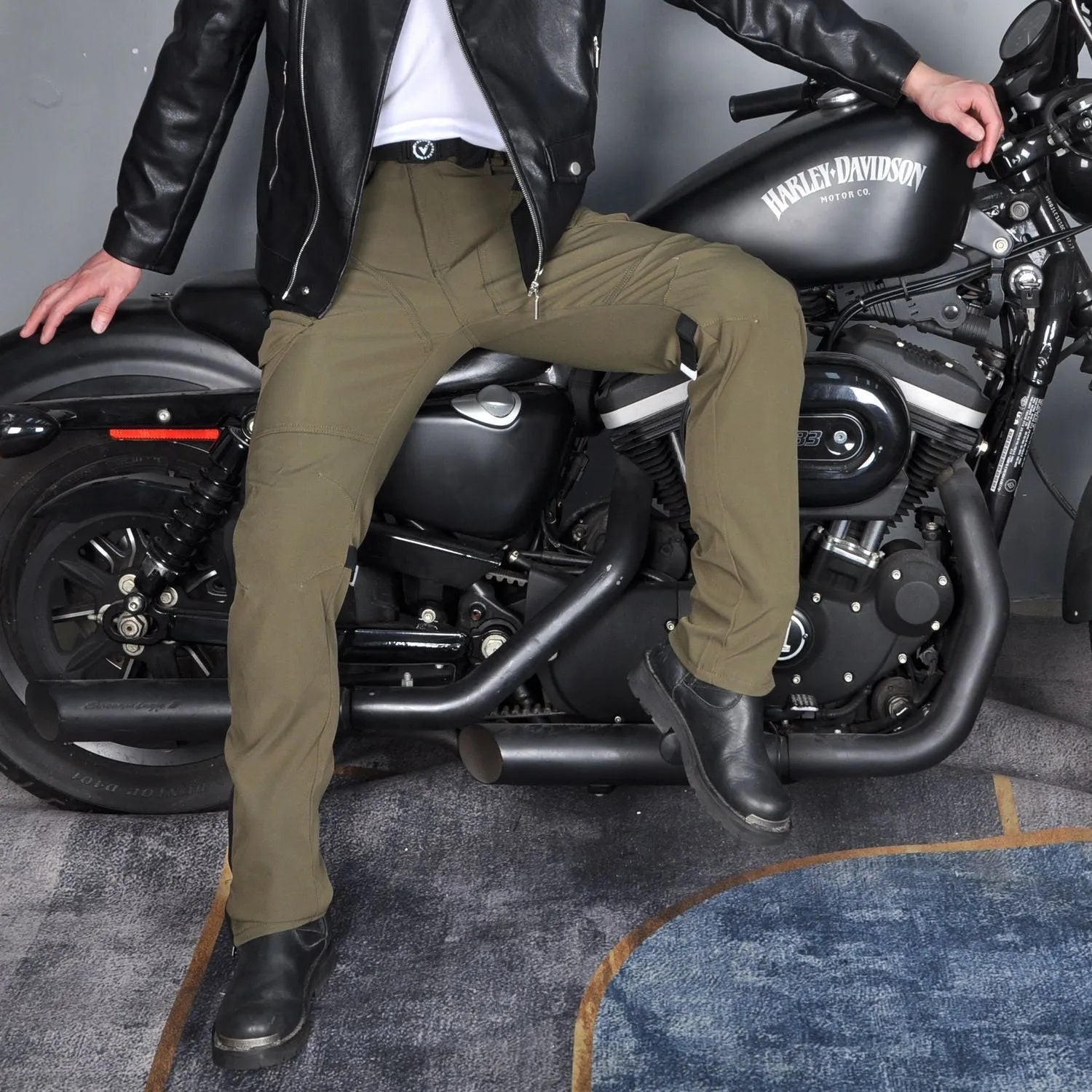 Men's black waterproof motorcycle cycling trousers with belt and protective gear on a hanger.