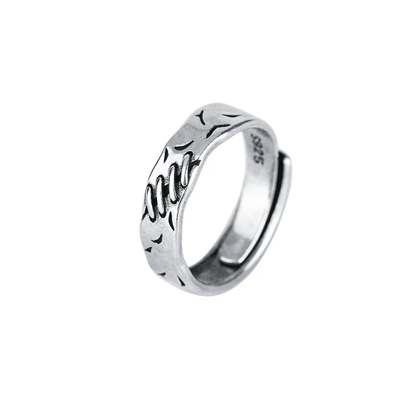 Black geometric copper ring with adjustable opening on a white background.