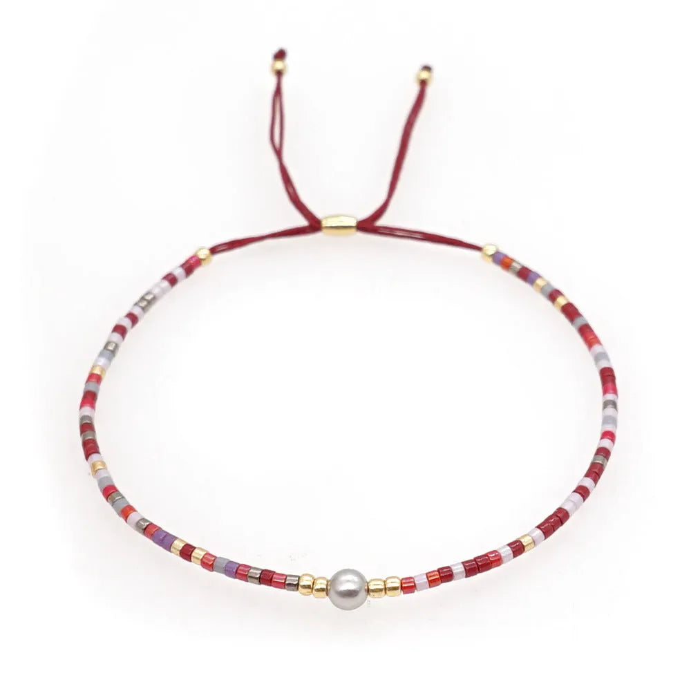 Close-up of a colourful handmade Bohemian bracelet with semi-precious stone and glass geometry beads on a wrist.