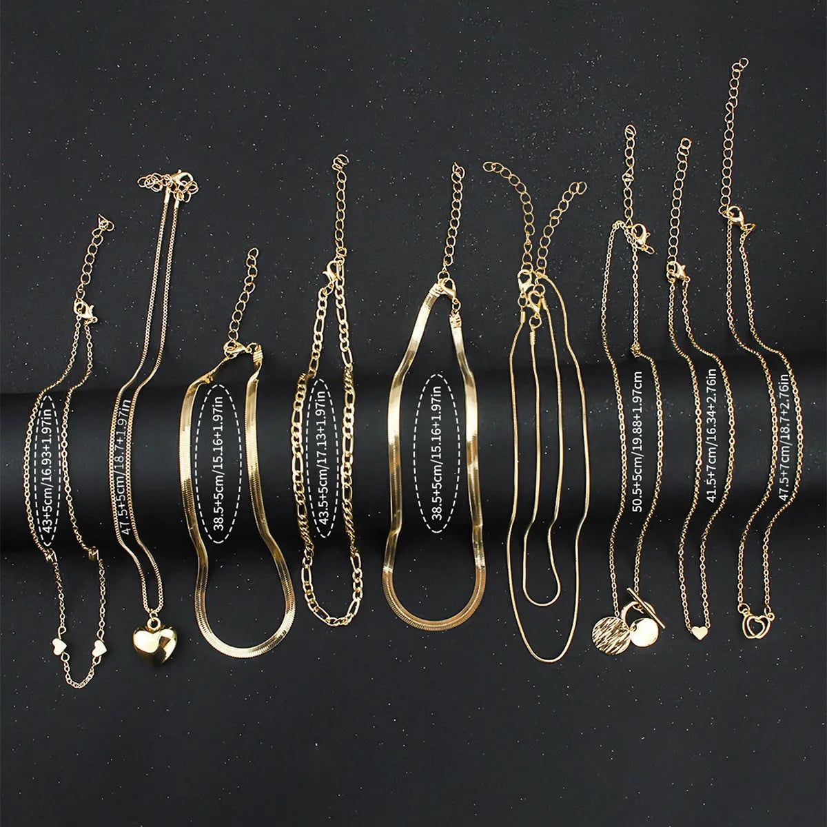 Ten gold-coloured women's necklaces with different alloy pendants on snake bone chains