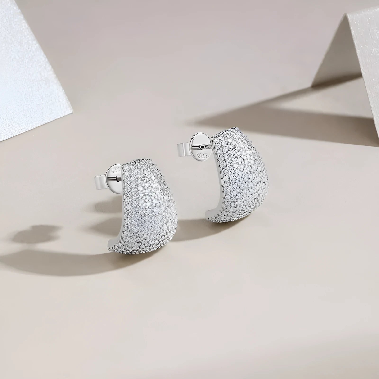 Geometric women's stud earrings in sterling silver with white moissanite stones, presented in a gift box.