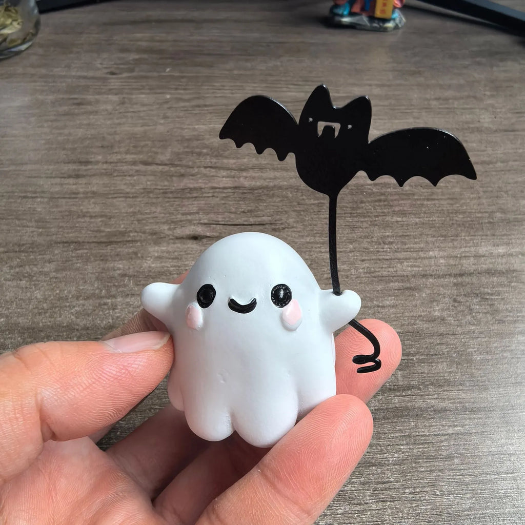 Small resin Halloween statue of a ghost walking a dog and holding a bat.