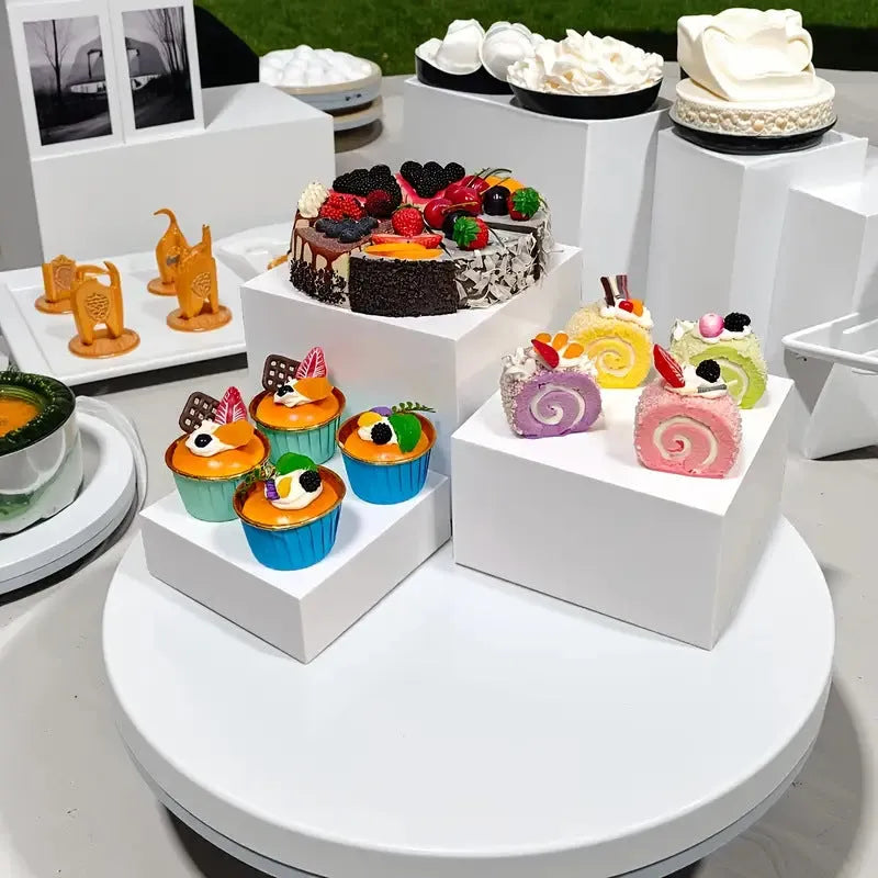 White plastic modular cube dessert display stand with six stackable units for cakes and pastries