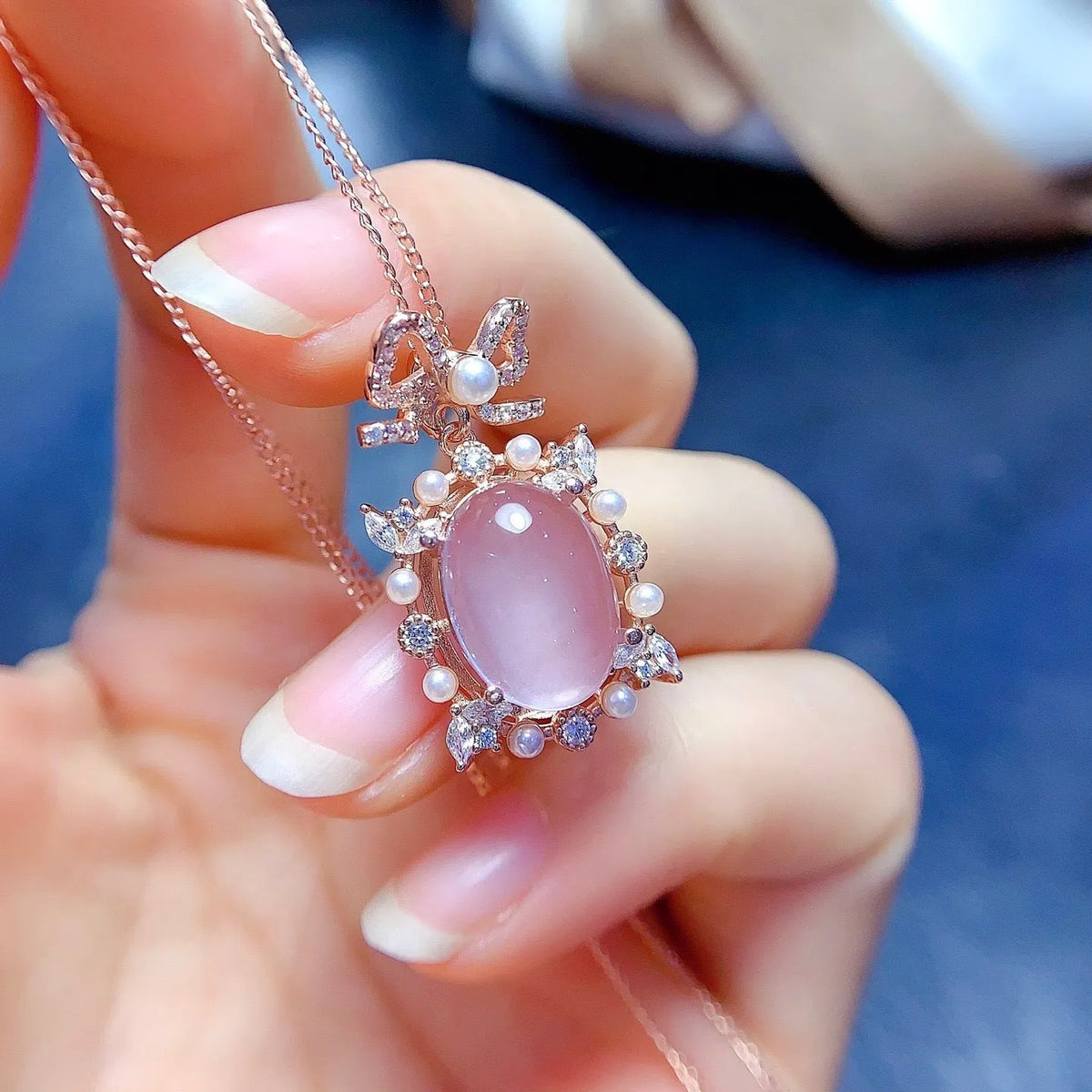 Geometric silver pendant necklace with a natural pink rose quartz crystal and a rose gold-plated setting.