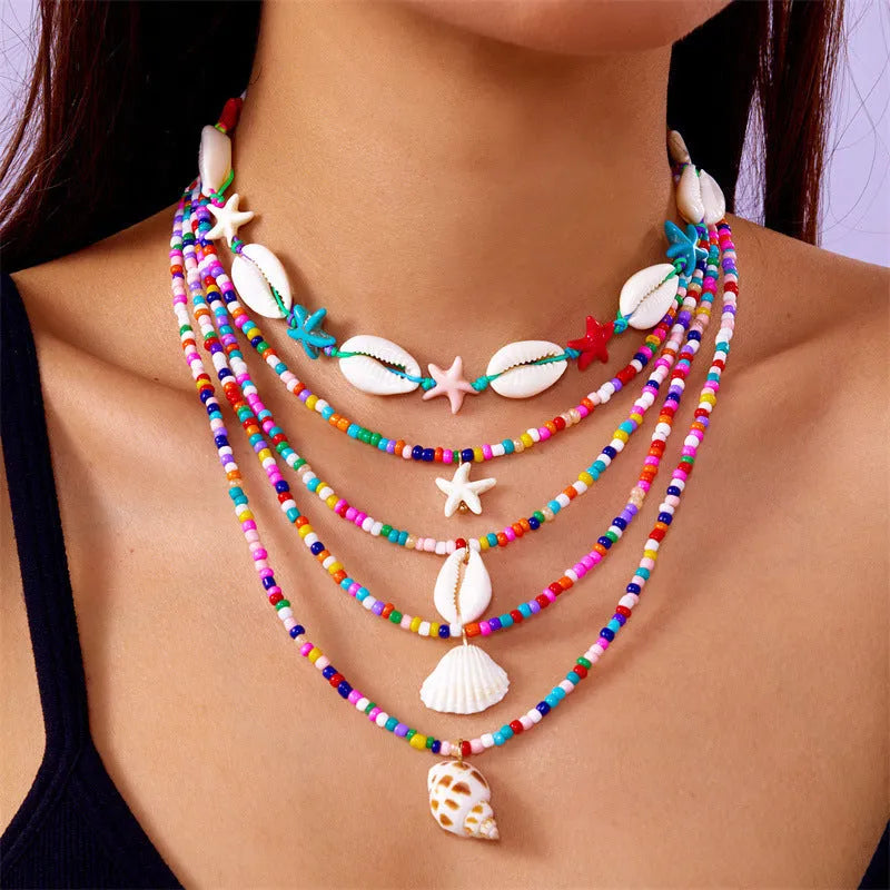 Blue and coloured multi-layer women's necklace set with starfish, shell, and conch beads on adjustable chain.