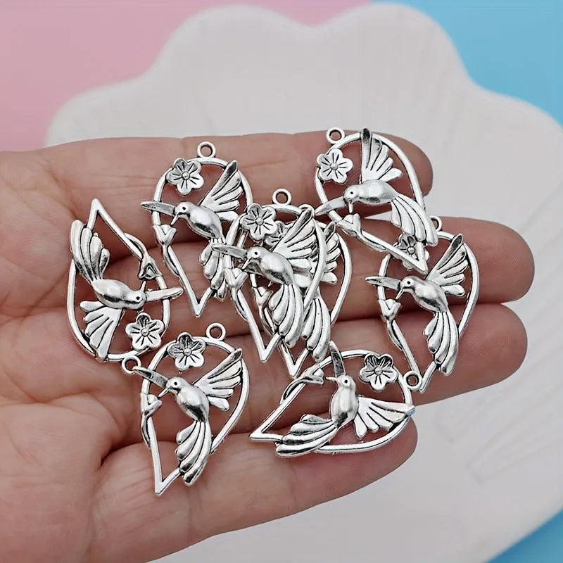 Close-up of an alloy pendant charm featuring a detailed magpie or cuckoo bird design with an electroplated finish.