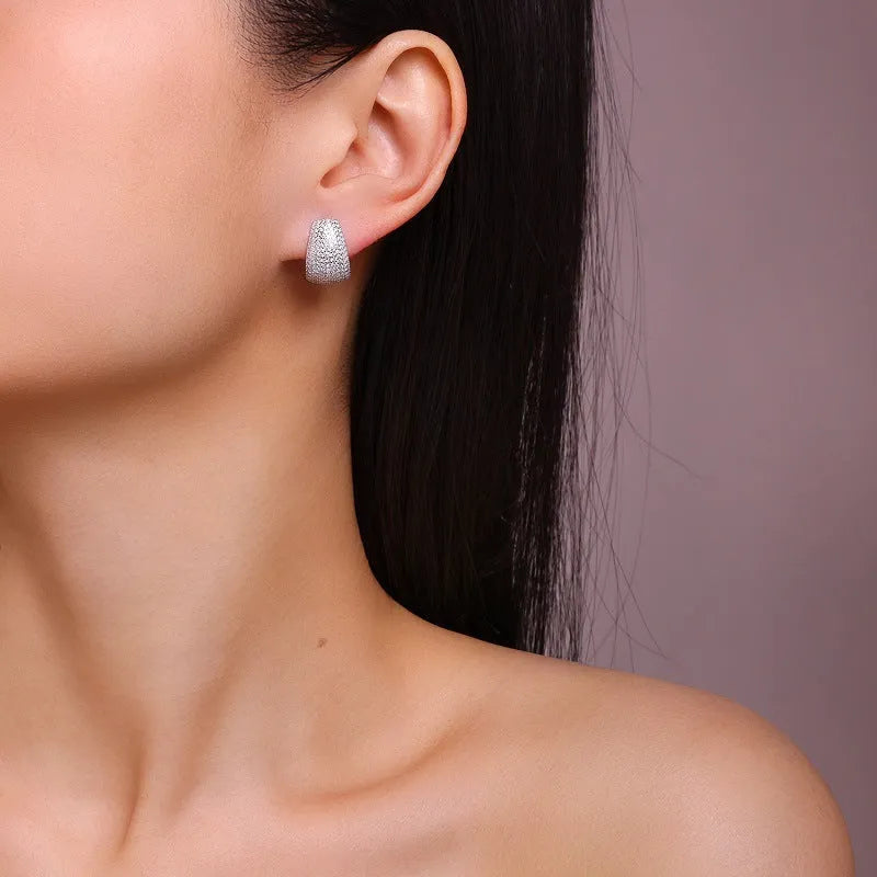 Geometric women's stud earrings in sterling silver with white moissanite stones, presented in a gift box.