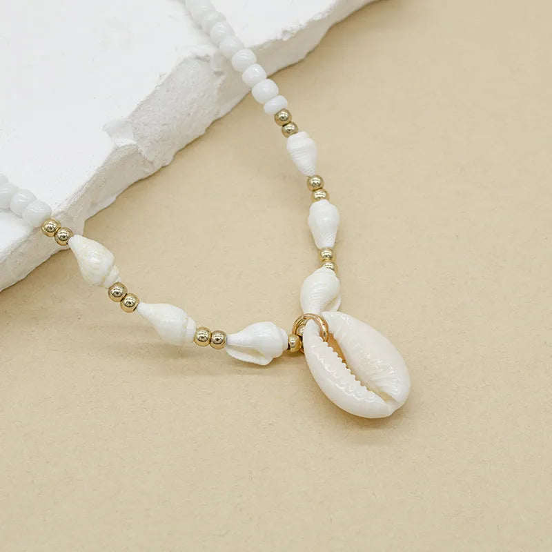 White conch shell necklace for women with a natural mother of pearl pendant on a chain.