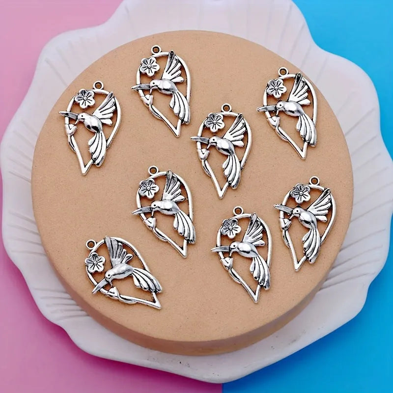 Close-up of an alloy pendant charm featuring a detailed magpie or cuckoo bird design with an electroplated finish.