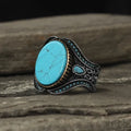 Men's antique silver round turquoise alloy ring on a plain background