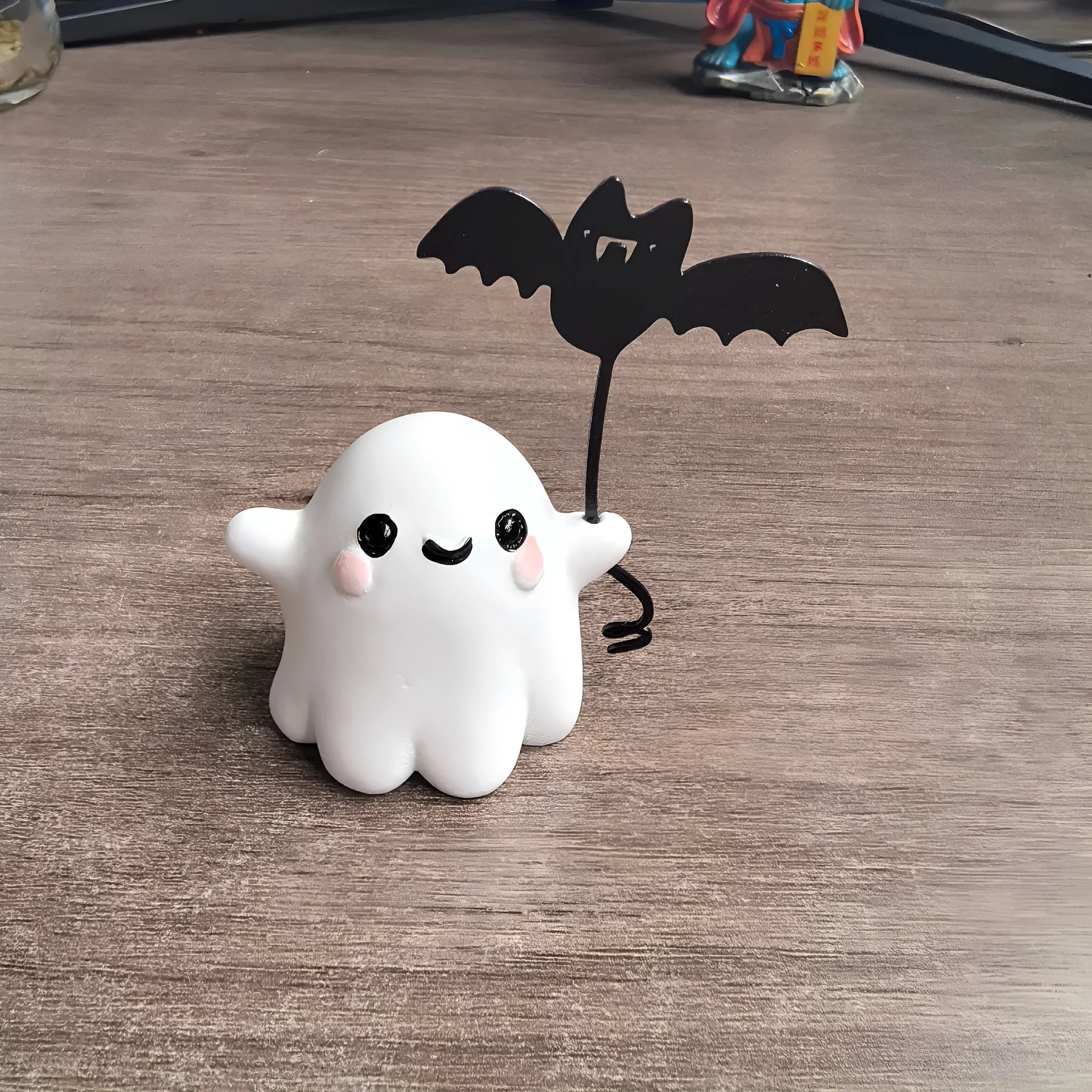 Small resin Halloween statue of a ghost walking a dog and holding a bat.