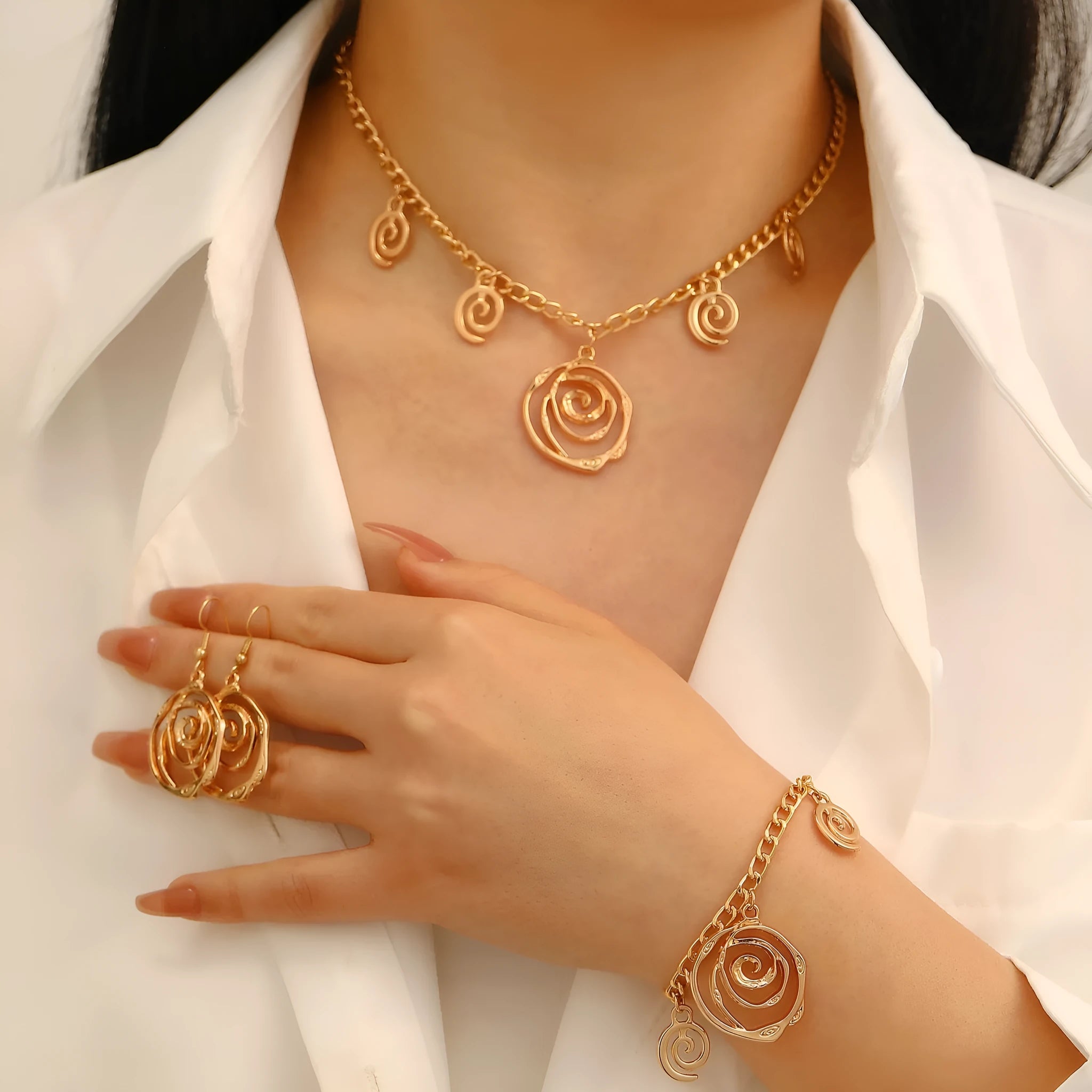 Spiral donut jewellery set showing necklace, bracelet and earrings in gold tone geometric circle design