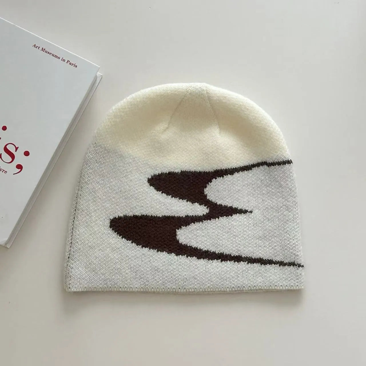 A knitted acrylic beanie hat in medium size, shown in black, grey, and white colour options.