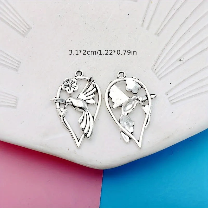 Close-up of an alloy pendant charm featuring a detailed magpie or cuckoo bird design with an electroplated finish.