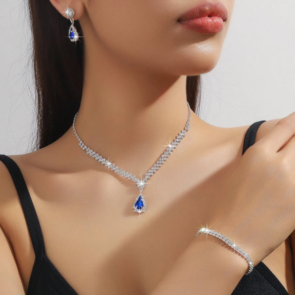 Claw chain necklace and matching earrings set with drop-shaped rhinestones in blue colour