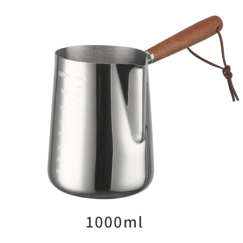 Stainless steel milk jug with measurement scale and wooden handle for barista latte art.