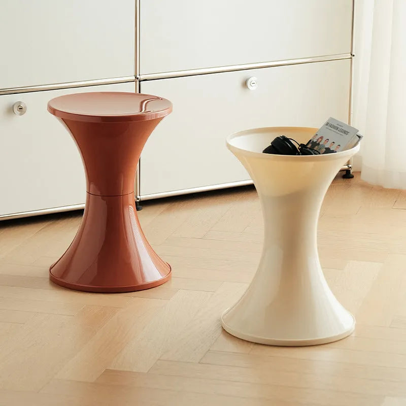 Plastic hourglass-style shoe changing stool in green, shown in a home entryway.