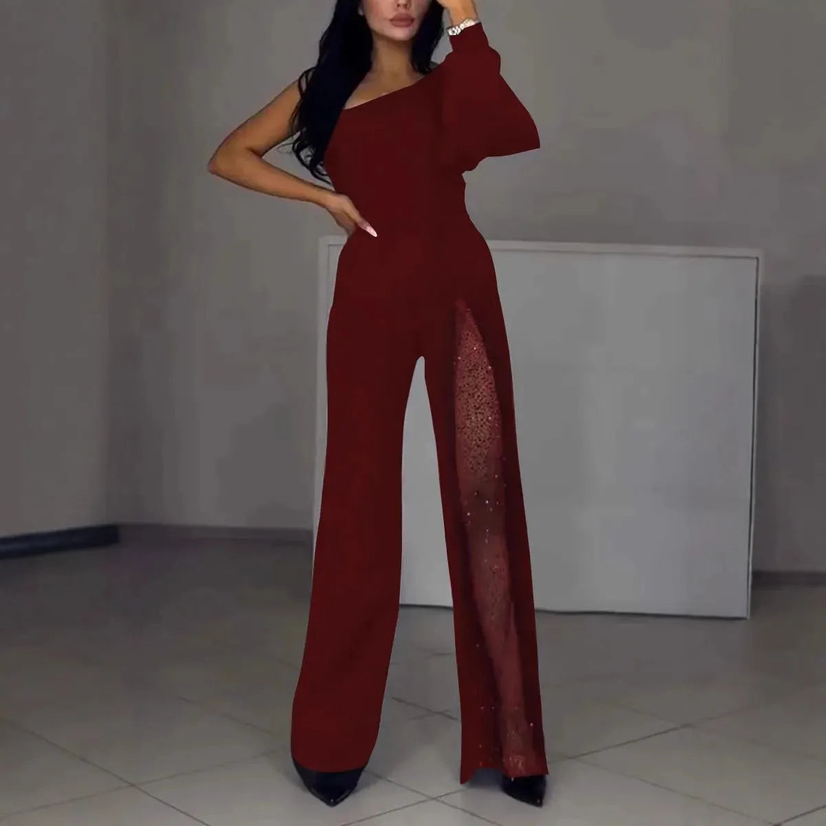 Black women's long sleeve jumpsuit with a high slit on the leg, made from thin polyester fabric.