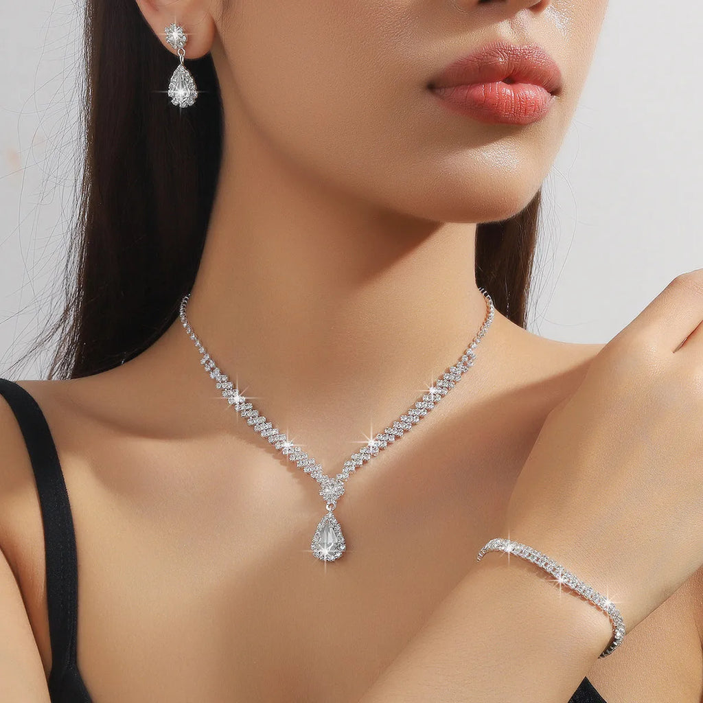 Claw chain necklace and matching earrings set with drop-shaped rhinestones in blue colour
