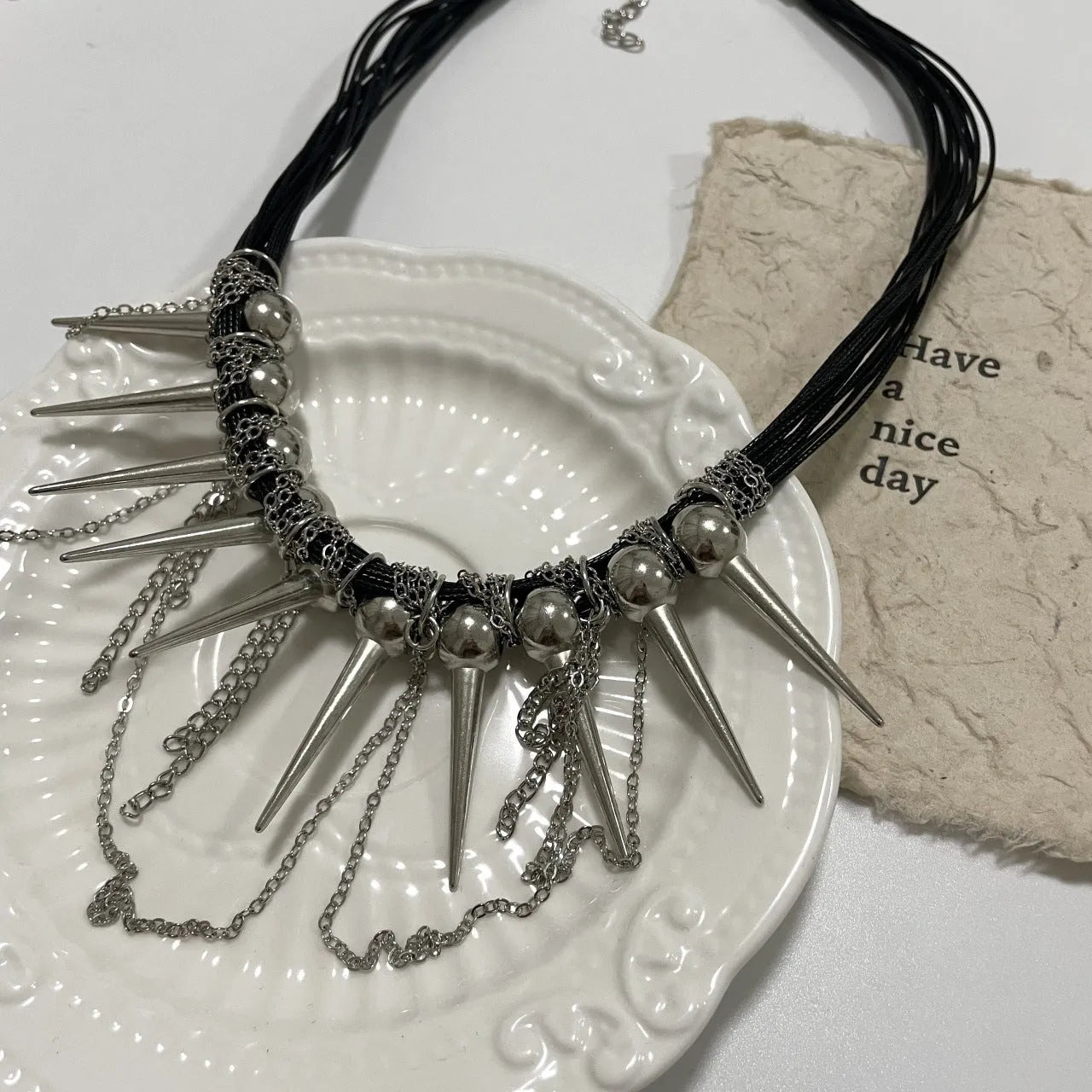 Women's leather necklace with winding tassel, round beads, and point rivets in electroplated finish